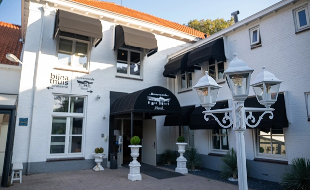 Sfeervolle entree van Hotel Hoevevoorde met klassieke details en zonwering, perfecte locatie voor een bedrijfsuitje met overnachting