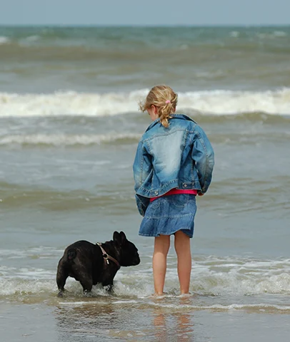 Meisje met hond in het water bij Scheveningen